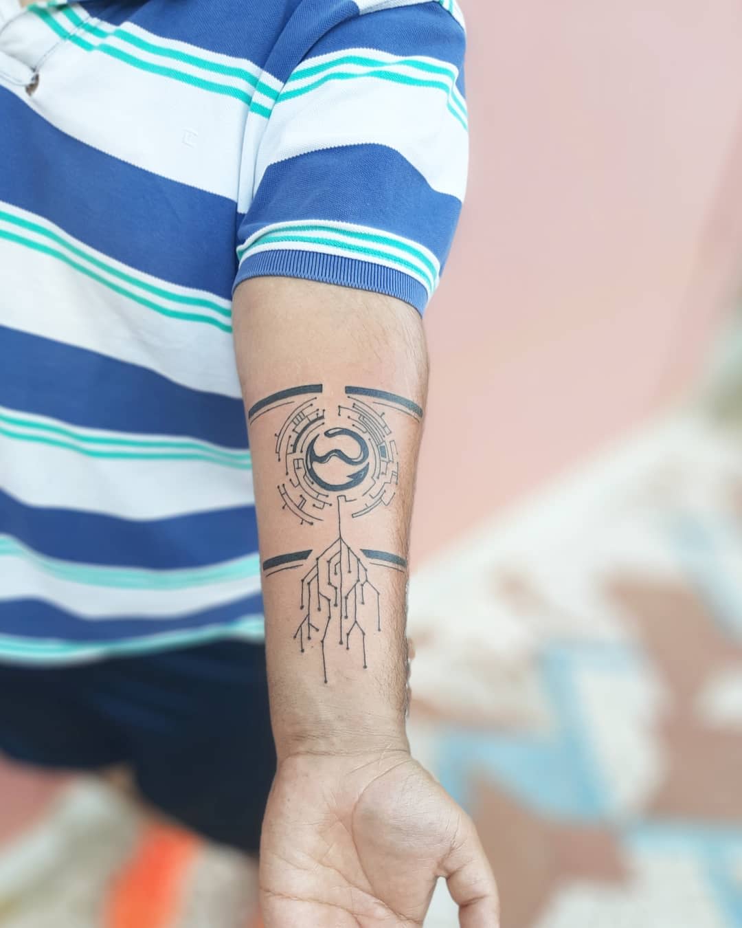 Simplistic cyberpunk tattoo on forearm, featuring a circular emblem and circuit-like design below